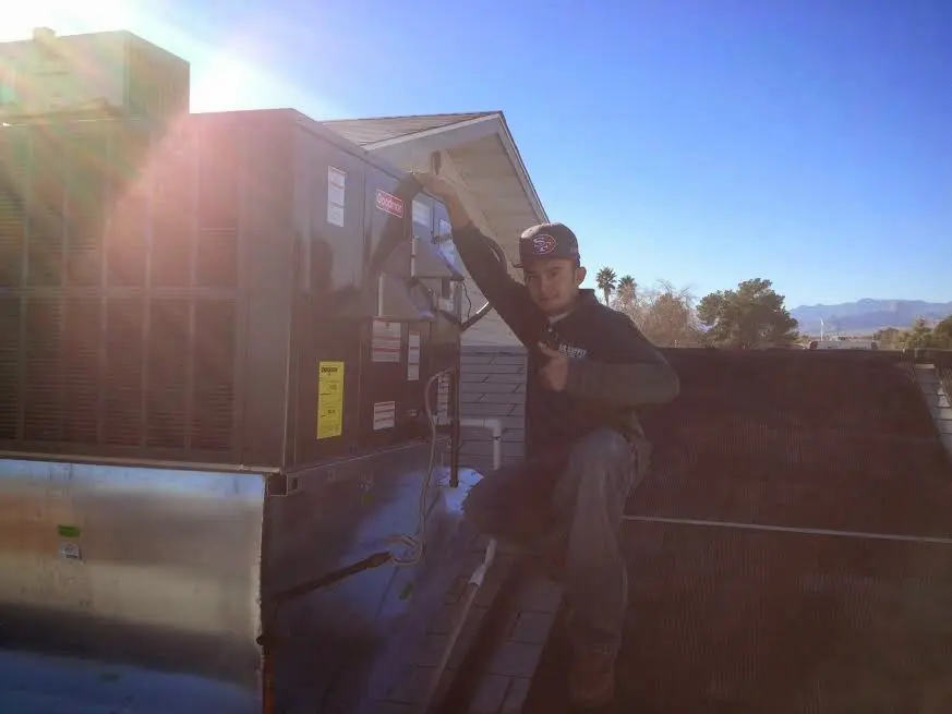HVAC technician performing Heat Pump Repair on a rooftop unit in Paw Paw